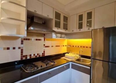 Modern kitchen with sleek cabinets, backsplash, and stainless steel appliances