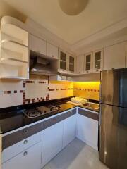 Modern kitchen with sleek cabinets, backsplash, and stainless steel appliances