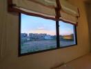 Bedroom with a view of the cityscape at sunset