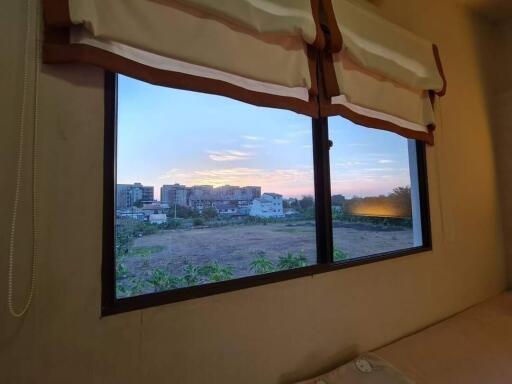 Bedroom with a view of the cityscape at sunset