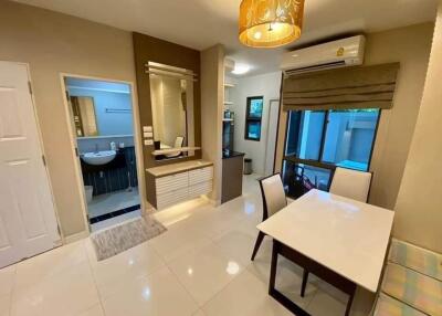 Modern living area with dining table and adjacent bathroom