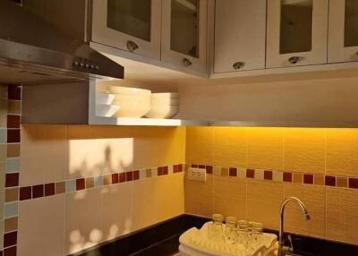 Modern kitchen with tiled backsplash and glass cabinets