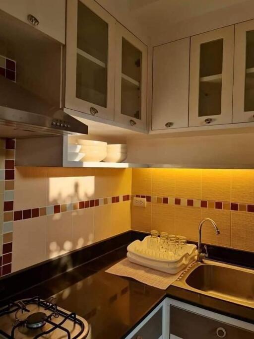 Modern kitchen with tiled backsplash and glass cabinets