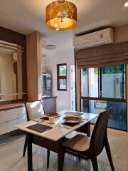 Modern dining area with a wall-mounted air conditioner, stylish table setting, and a view of the backyard