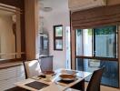 Modern dining area with a wall-mounted air conditioner, stylish table setting, and a view of the backyard