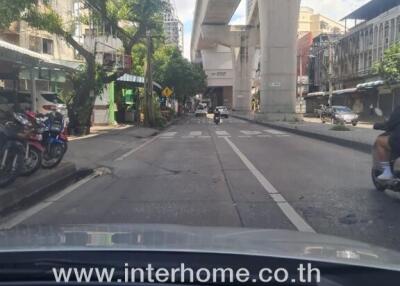 Street view with elevated train tracks and surrounding buildings