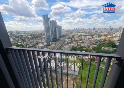 Cityscape view from a balcony with nearby tall buildings and wide view of the surroundings