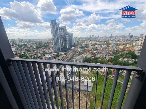 Cityscape view from a balcony with nearby tall buildings and wide view of the surroundings