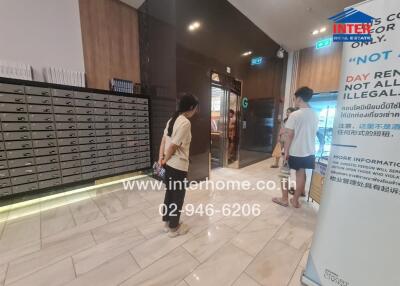 Lobby area with mailboxes and people walking