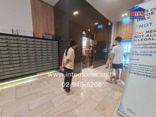 Lobby area with mailboxes and people walking