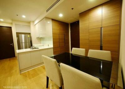 Modern kitchen and dining area with wooden cabinets and integrated lighting