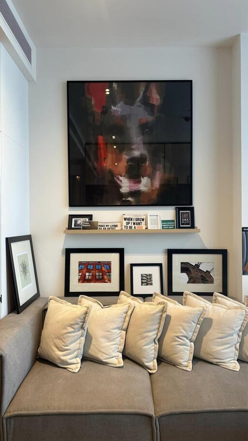 Cozy living room area with a comfortable couch and framed artwork on the wall.