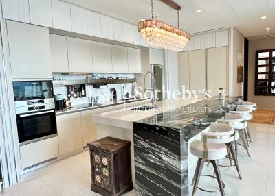 Modern kitchen with marble island and chandelier