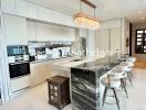 Modern kitchen with marble island and chandelier