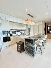 Modern kitchen with marble countertops and island.