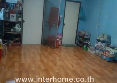 Living room with wooden flooring and storage shelves