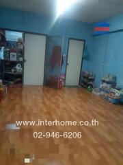 Living room with wooden flooring and storage shelves