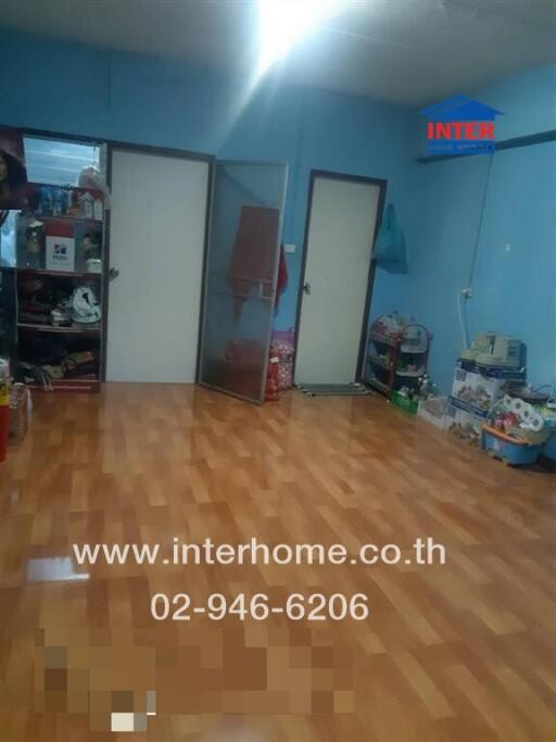 Living room with wooden flooring and storage shelves