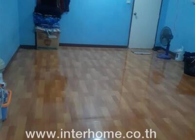 Empty bedroom with polished wooden floor and blue walls