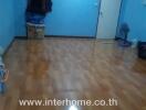 Empty bedroom with polished wooden floor and blue walls