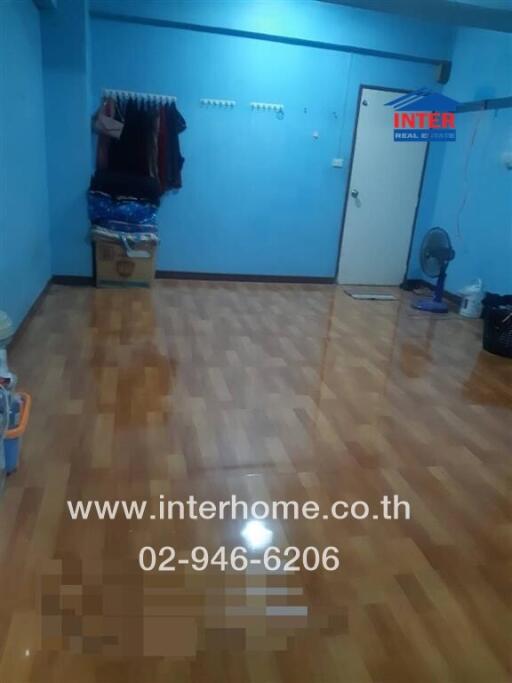 Empty bedroom with polished wooden floor and blue walls