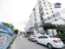 Exterior view of a multi-story apartment building with parked cars