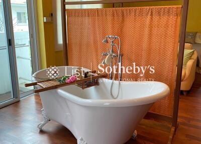 Freestanding bathtub in a bathroom with wooden floors