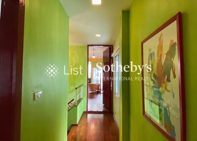 Bright hallway with green walls and wooden flooring