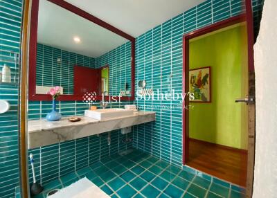 Modern bathroom with teal tiles and a large mirror