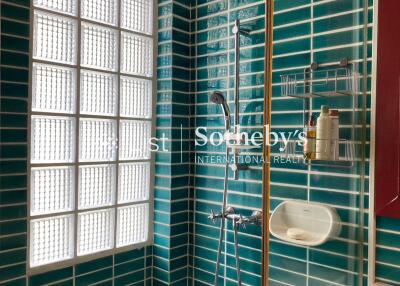 Modern bathroom with green tiling and glass block window