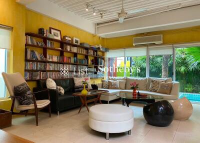 Cozy living room with bookshelves and pool view