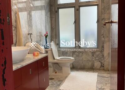 Modern bathroom with marble tiles and red vanity