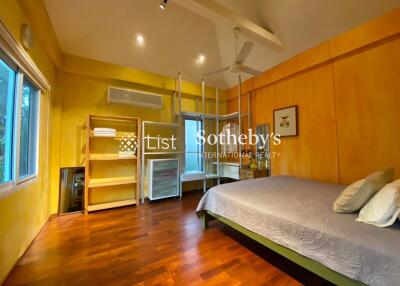 Spacious bedroom with wooden flooring and yellow walls