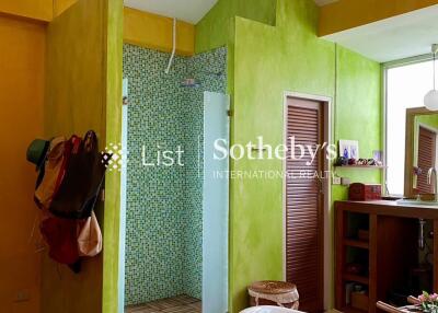 Modern bathroom with bright green walls, shower area, and freestanding bathtub