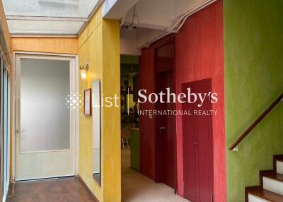 Colorful hallway with natural light and wooden staircase