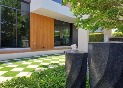 Modern building facade with green lawn and stylish stone water features