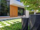 Modern building facade with green lawn and stylish stone water features