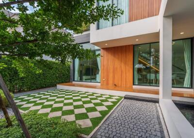 Modern house exterior with a checkered lawn and greenery