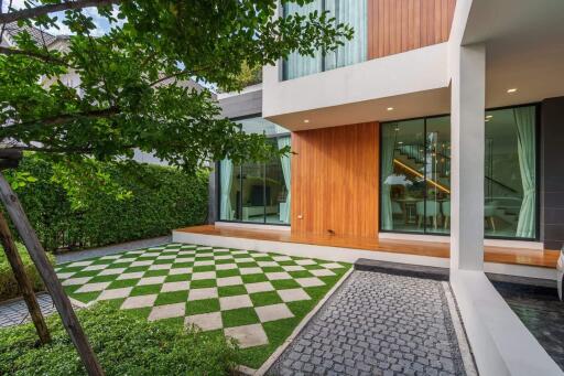 Modern house exterior with a checkered lawn and greenery