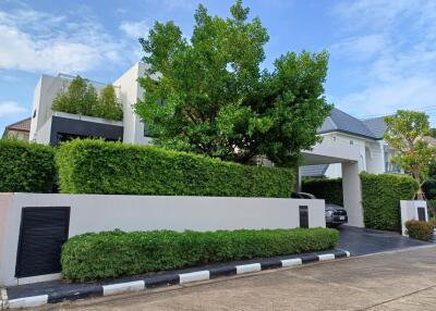 Front view of a modern house with lush greenery