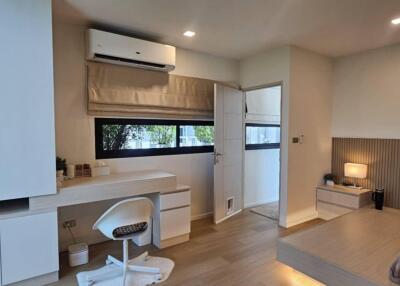 Modern bedroom with desk, air conditioner, and platform bed