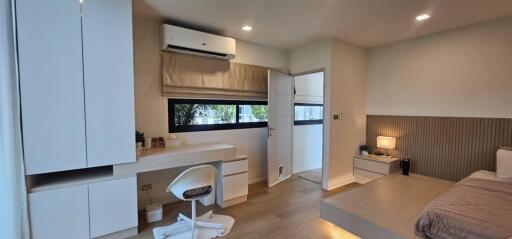 Modern bedroom with desk, air conditioner, and platform bed