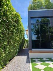 Modern exterior view with large windows and lush greenery