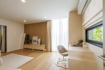 Well-lit modern bedroom with work desk and large window