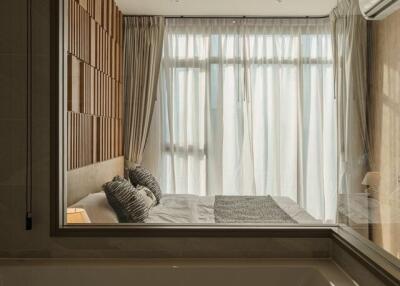 Modern bedroom with large windows and a view from the bathroom