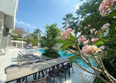 Outdoor swimming pool area with seating and plants