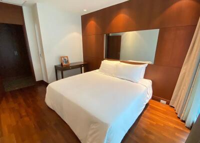 Bedroom with wooden floors and a large bed