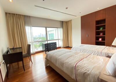 Bright bedroom with twin beds, desk, and large window