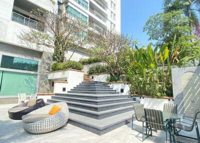 Outdoor seating area with modern stairs and greenery