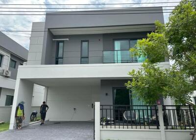 Modern two-story house with people working outside